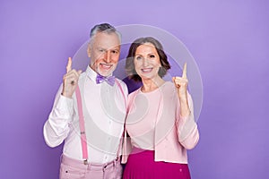 Portrait of cheerful two people indicate fingers up empty space banner isolated on violet color background