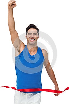 Portrait of cheerful winner athlete crossing finish line