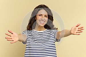 Portrait of cheerful woman with excited smile and hands raised for embrace. Give me a hug concept