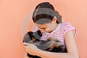 Portrait of a cheerful woman holding and looking at an adorable small puppy