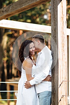 Portrait of cheerful woman and man spending time together outdoors, kissing, hugging and laughing on summer terrace, couple in