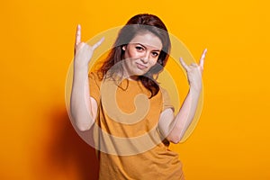 Portrait of cheerful woman showing rock sign with hands