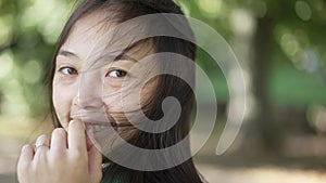 Portrait of cheerful woman spinning looking at camera smiling on sunny day in summer park. Close-up of young slim Asian