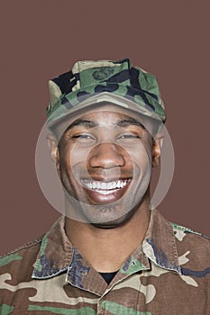 Portrait of a cheerful young African American US Marine Corps soldier over brown background photo