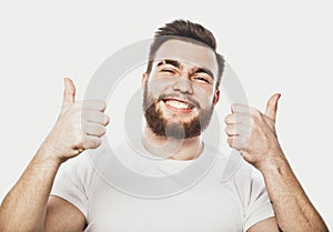 Portrait of a cheerful young bearded man showing okay gesture isolated on the white background