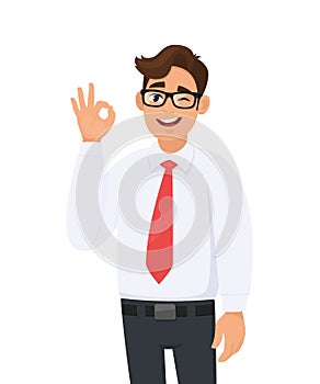 Portrait of a cheerful young business  man showing/gesturing/making okay or ok sign with hand and fingers while winking eye.