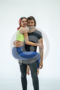 Portrait of cheerful young couple standing together over white background