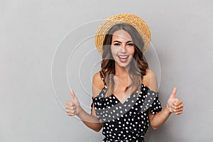 Portrait of a cheerful young girl in dress and straw hat