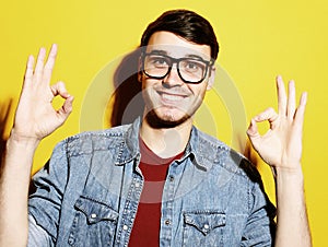 Portrait of a cheerful young man showing okay