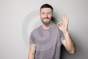 Portrait of a cheerful young man showing okay gesture