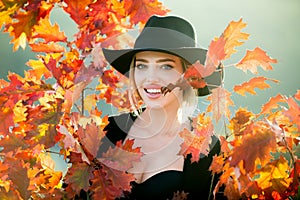 Portrait of cheerful young woman with autumn leafs. Autumn woman with yellow maple leaves on golden fall. Happy smiling