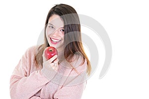 Portrait of cheerful young woman eating red apple with back copy space