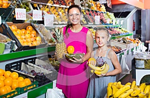 Woman with child buying fruits