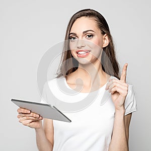 Portrait of cheerful young woman holding digital tablet