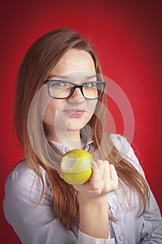 Portrait of a cheerful young woman holding green apple to enjoy the taste. Dieting, healthy eating and organic food concept