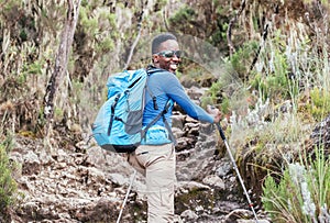 Portrait of a cheerfully smiling African-American Ethnicity young man in sunglasses. He having a walk with a backpack using