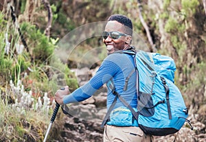 Portrait of a cheerfully smiling African-American Ethnicity young man in sunglasses. He having a walk with a backpack using