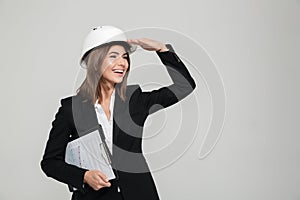 Portrait of a cheery woman in hard hat and suit