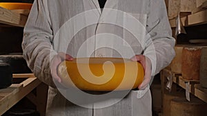 Portrait Of A Cheesemaker Worker Holding Cheese In His Hands And Looking At The