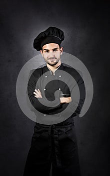 Portrait of a chef cooker in black uniform.