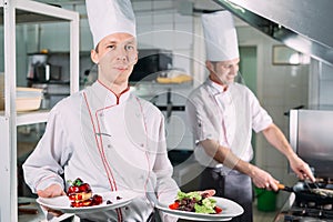 Portrait of the Chef in the kitchen of the restaurant with a ready-made dish Foie Gras.