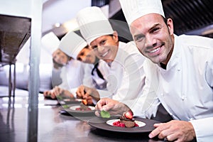 Portrait of chefs team finishing dessert plates