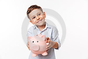 Portrait of a cherry cute little kid holding piggy bank