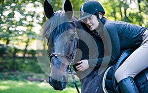 Portrait of chestnut horse with lady-equestrian hugs her neck