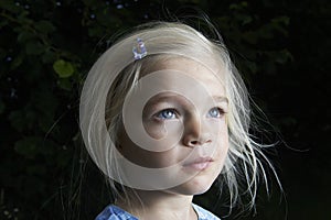 Portrait of child blond girl looking up