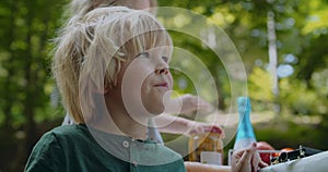 Portrait of child boy chewing some food outdoors