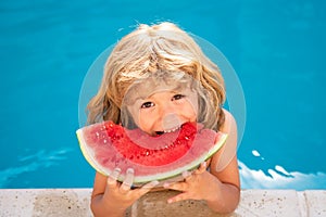 Portrait of child boy eating a slice of watermelon by a swimming pool having fun playing summer holiday, outdoors