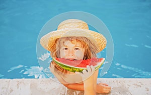 Portrait of child boy eating a slice of watermelon by a swimming pool having fun playing summer holiday, outdoors