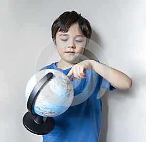 Portrait child boy is looking at a globe, Selective focus School kid  learning about Geography, Education and Home schooling