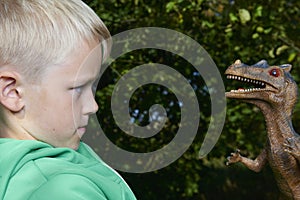 Portrait of child boy playing with toy dinosaur