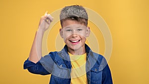Portrait child boy smiling pointing forefinger having good idea solving problem posing isolated