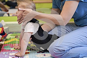 Portrait of a child with cerebral palsy on physiotherapy in a children therapy center. Boy with disability has therapy by doing