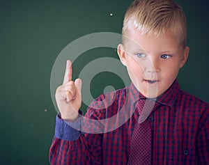 Portrait of child in classroom. Success, idea and innovation technology concept. Back to school. Kid against blackboard