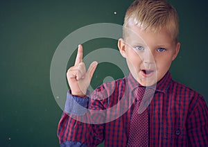 Portrait of child in classroom. Success, idea and innovation technology concept. Back to school. Kid against blackboard