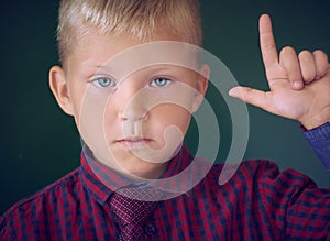 Portrait of child in classroom. Success, idea and innovation technology concept. Back to school. Kid against blackboard