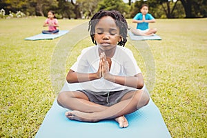 Portrait of child doing yoga with friends