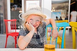 Portrait of a child that is having a good time on a cafe terrace
