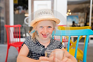 Portrait of a child that is having a good time on a cafe terrace