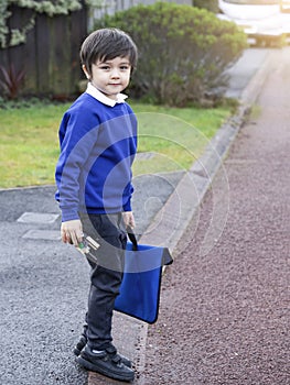Portrait of Child  holding toy and carrying bag waiting for schoolbus, Pupil of primary school get ready to studying, Student back
