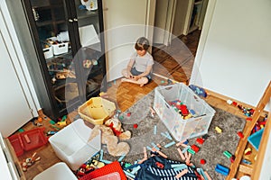 Portrait of a child playing in a very messy room