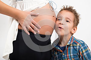 Portrait of a child and a pregnant woman. The listens to what is going on in my mother`s belly
