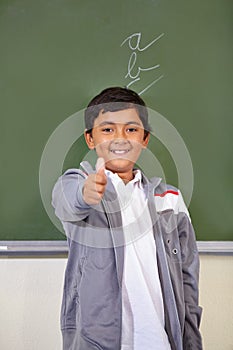 Portrait, child and thumbs up of student on chalkboard in classroom, elementary school and mockup. Blackboard, education