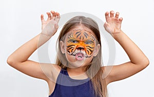 Portrait child with tiger face painting with gnarling facial expression