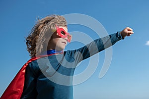 Portrait of child wearing a superhero costume. Super hero child having fun outdoors. Kids power concept.