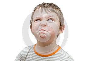 Portrait of a child on a white background. The boy ridiculously writhes his face, playful, funny facial expression. emotion.