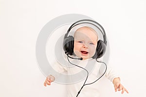 Portrait of a child on a white background with headphones. stay home, coronavirus 19. Baby 6 months listening to music. Space for